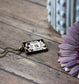 Vintage Art Nouveau Lace Rectangle Pendant With Flower On Burgundy Cotton Background